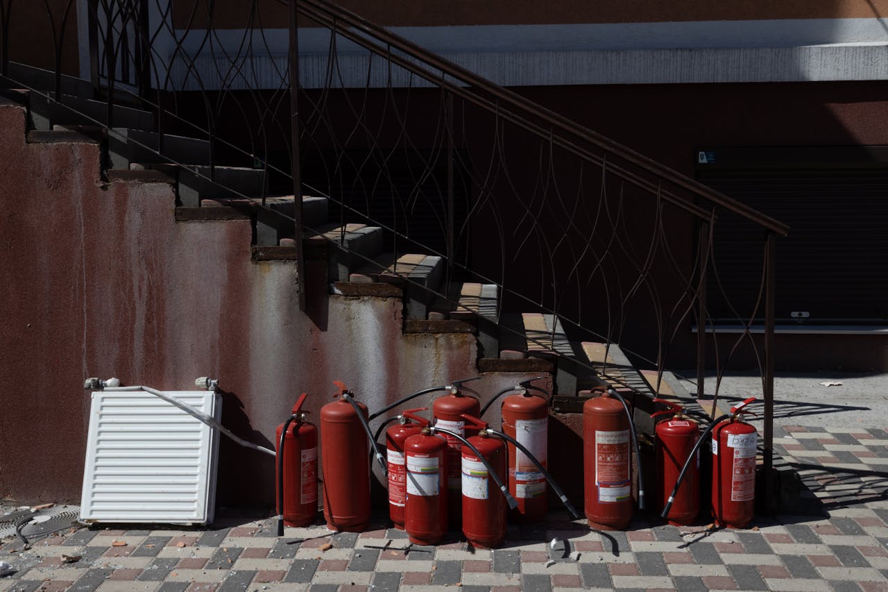 Fire Extinguishers Near the Concrete Stairs with Metal Railings